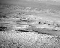 Opportunity takes in the panoramic view while crossing some rocky terrain
